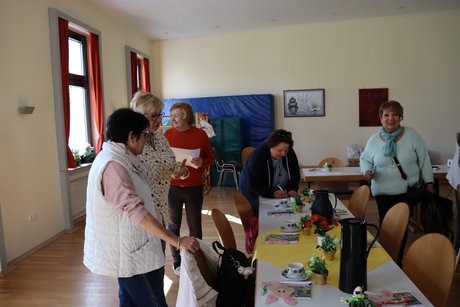 Treffen der Vertreterinnen der Frauen im Mehrgenerationenhaus. Mehrere Fraue stehen am gedeckten Tisch und unterhalten sich.