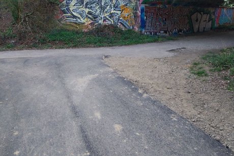 Das Bild zeigt einen Weg, der kurz vor einem Tunnel nach rechts scharf abbiegt.