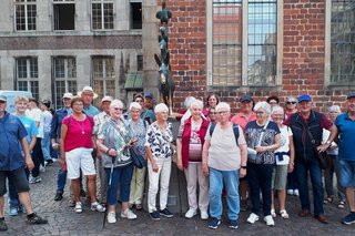 Die Reisegruppe auf dem Marktplatz in Bremen vor der Skulptur der Bremer Stadtmusikanten