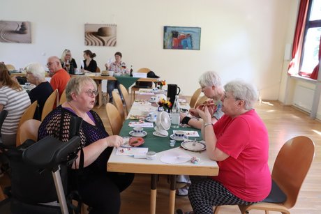 Treffen der Vertreterinnen der Frauen. Mehrere Frauen sitzen an einem langen Tisch und unterhalten sich miteinander.