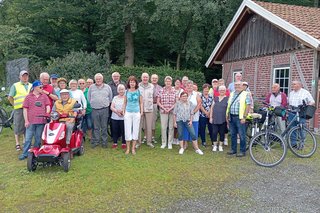 Ca. 30 Personen stehen seitlich der Schutzhütte in der Bauernschaft Büren