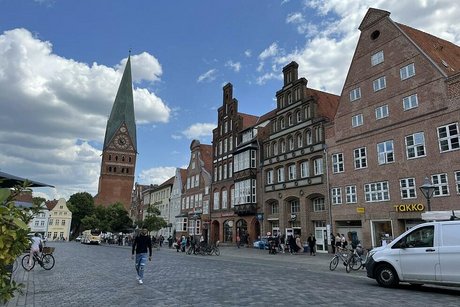 Alte Giebelhäuser und ein großer Kirchturm in der Altstadt von Lüneburg.