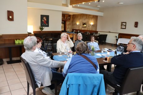 Frühlingsfest Mehrere Personen sitzen an einem Tisch und unterhalten sich.