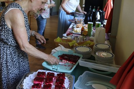 Treffen der Vertreterinnen der Frauen. Zwei Frauen treffen letzte Vorbereitungen am Kaffee und Kuchen Buffet.