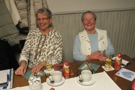 2 Frauen sitzen an einem gedeckten Tisch.