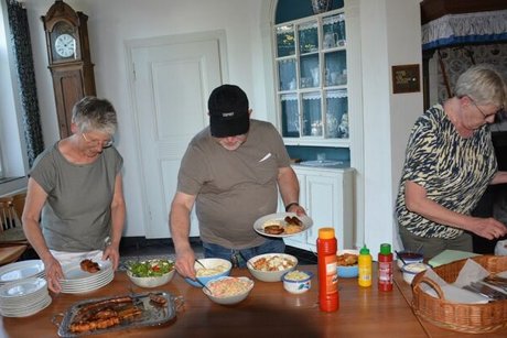 Zwei Frauen und ein Mann bedienen sich am Salatbuffet.