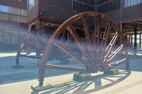 In den Boden als Denkmal eingefasst zwei halbe Förderräder der ehemaligen Zeche.