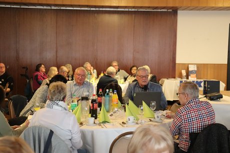 Mehrere Personen sitzen an einem runden Tisch.