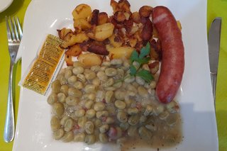 Dicke Bohnen mit Bratkartoffeln und Wurst.