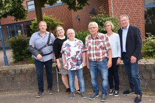 Gruppenfoto mit sechs der aktuell sieben Mitglieder des VdK-Vorstands. Im Hintergrund eine Hecke und ein rotverklinkertes Gebäude.