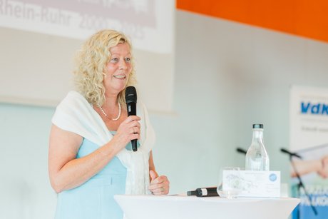 Eine Frau spricht in ein Mikrophon.