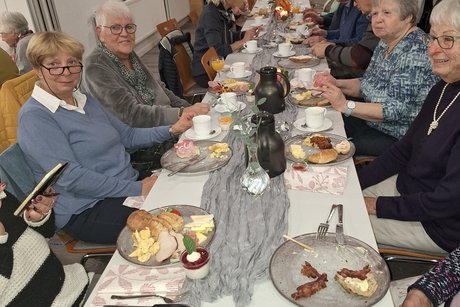 Viele VdK-Mitglieder sitzen am Tisch und genießen gute Gespräche und erin leckeres Frühstück.