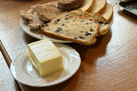 Das gebackene Brot steht auf dem Tisch gebackenes Brot und die Butter dazu stehen auf einem Tisch