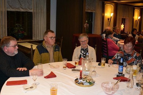 Mitglieder sitzen am Tisch beim Weihnachtsessen