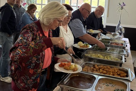 Imbiss nach der Versammlung für die Mitglieder Menschen greifen beim Buffett zum Essen