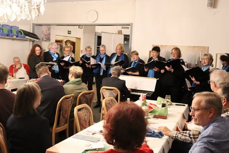 Ein Chor singt vor den Mitgliedern.