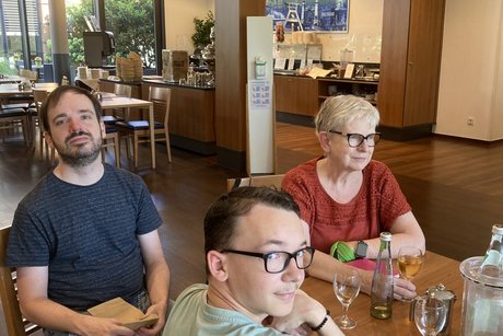 Menschen sitzen an einem langen Tisch .