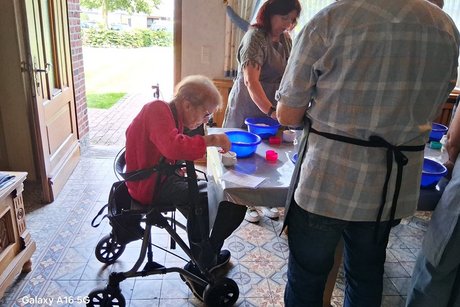 Teigherstellung Eine Teilnehmerin mit Rollator bei der Brotteigherstellung
