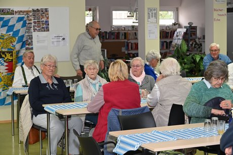 Mitglieder sitzen an einem Tisch bei einer Unterhaltung