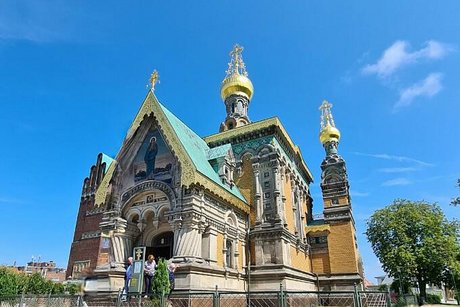 Foto aus der Froschperspektive auf die gelb, verklinkerte, russisch-orthodoxe Kirche mit ihren goldenen Türmchen.