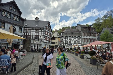 Menschen auf einem Platz in Monschau mit Fachwerkh&auml;usern.