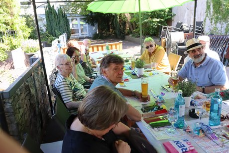 Mehrere Menschen sitzen an einem langen Tisch.