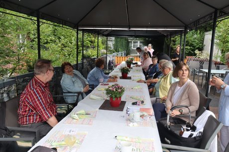 Grillnachmittag vom VdK Ortsverband Altendorf gemeinsam mit dem Ortsverband Borbeck. Die ersten Teilnehmer sitzen an einem langen Tisch im Außenbereich unter einem Pavillon.