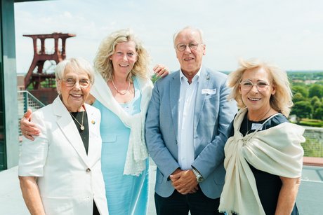 Drei Frauen und ein Mann stehen zusammen für ein Foto.