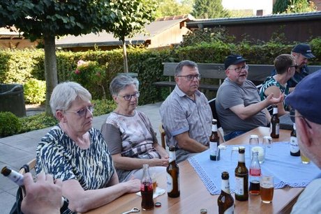 Menschen sitzen gemeinsam mit Kaltgetränken an einem Tisch.