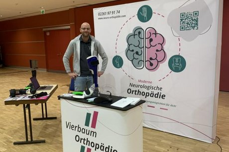 Das Bild zeigt einen Vertreter für Orthopädietechnik und Sanitätsfachhandel an einem Messestand