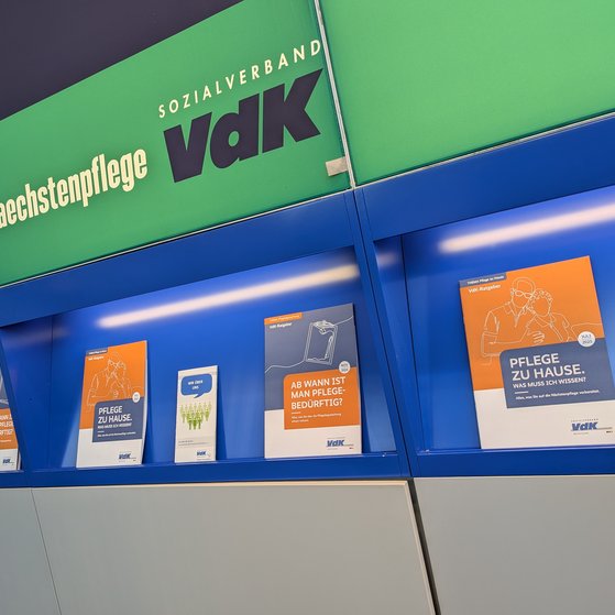 Messewand mit Slogan #naechstenpflege und VdK-Logo. Darunter Brosch&uuml;ren des VdK zum Thema Pflegebegutachtung und Pflege zu Hause.