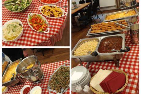 Man sieht eine Tisch Reihe auf dem verschiedene Sch&uuml;sseln, Warmhalte Platten, So&szlig;en und verschiedene Salate stehen.Es ist ein reichhaltiges Buffet zu sehen.