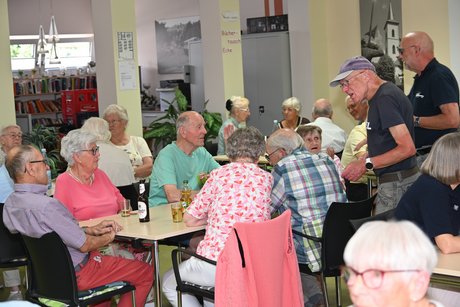 Menschen sitzen am Tisch bei einer Unterhaltung
