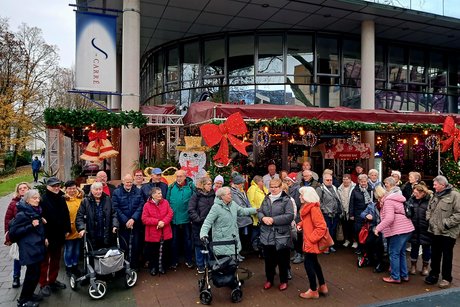 Gruppenbild mit Teilnehmern vor weihnachtlicher Kulisse