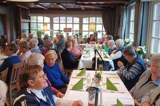 Meschen in der Gaststätte am gedeckten Tisch.