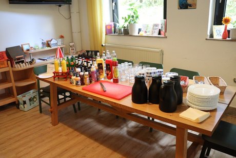 Vorbereitungen sind fertig. Gedeckter Tisch mit Getränken und Geschirr.