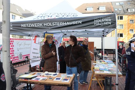 Auftaktveranstaltung internationale Wochen gegen Rassismus in Essen Holsterhausen. Menschen stehen hinter dem Stand vom Netzwerk Holsterhausen.