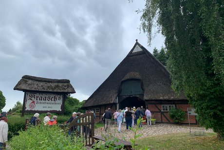 Räucherkate Harmsdorf Menschen auf dem Weg in eine Räucherkate