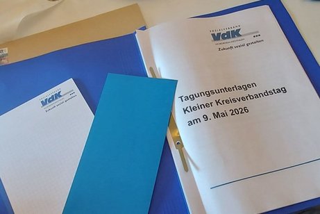 Das Bild zeigt Tagungunterlagen mit Notizblock und Stimmkarte