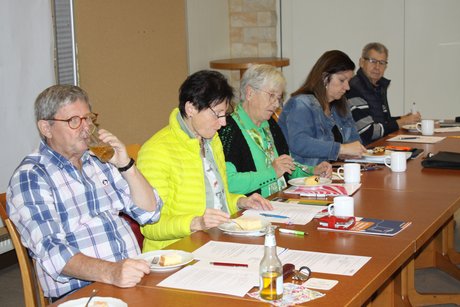 Teil des Vorstandes Fünf Mitglieder (Frauen und Männer)des Vorstandes sitzen an Tischen