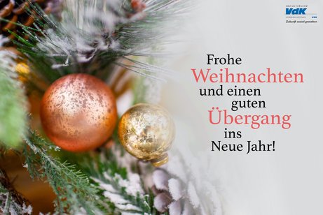 Weihnachtsmotiv: Schneebestäubte Tannenzweige und Weihnachtskugeln in Gold und Kupfer. Daneben in grüner Schrift: Frohe Weihnachten und einen guten Übergang und das VdK-NRW-Logo.