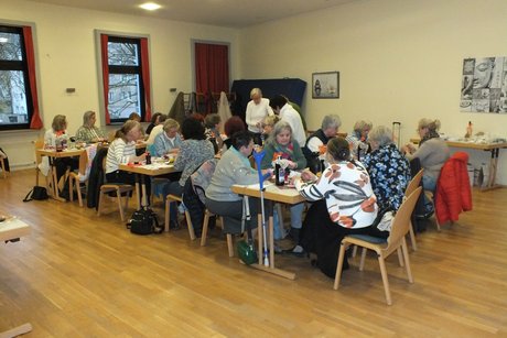Jahresabschlusstreffen der Frauenvertreterinnen. Etwa 30 Frauen sitzen an langen Tischen und basteln.