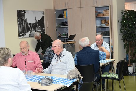 Mitglieder sitzen an einem Tisch bei einer Unterhaltung