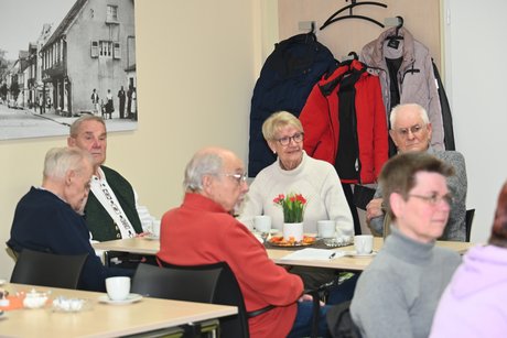 Mitglieder sitzen an einem Tisch und unterhalten sich