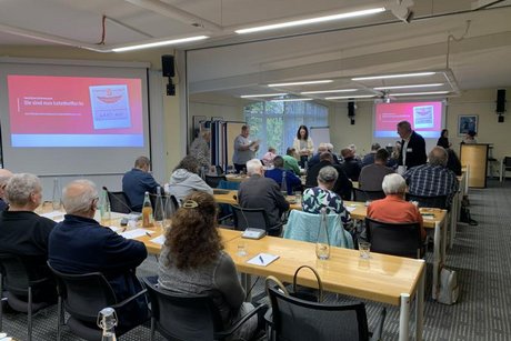 Das Bild zeigt den H&ouml;rsal mit aufmerksamen Zuh&ouml;rer/innen