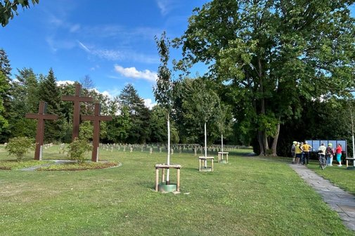 Soldatenfriedhof Mönchengladbach-Hardt Das Bild zeigt eine Kriegsgräberstätte im Vordergrund links drei große rostfarbene Eisenkreuze.