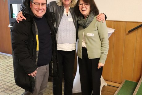 Ein Mann und zwei Frauen stehen f&uuml;r ein Foto zusammen.