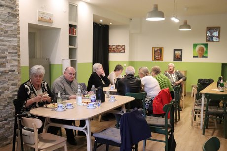 Mitglieder und Gäste vom Ortsverband. Mehrere Personen sitzen an zwei Tischen und unterhalten sich.