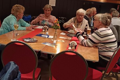 Auf dem Bild sieht man unsere Mitglieder (vier Frauen) an einem gro&szlig;en Tisch.