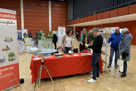Das Bild zeigt eine Vertreterin des Verbraucherschutzes am Messestand im Gespräch mit Interessierten